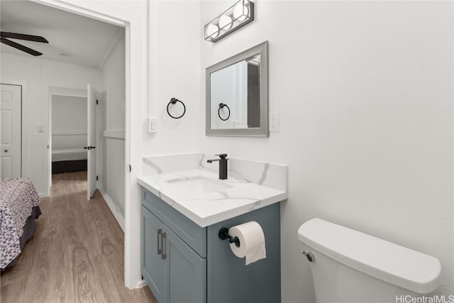 bathroom featuring vanity, hardwood / wood-style flooring, toilet, and ceiling fan