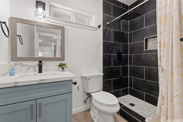 bathroom featuring curtained shower, vanity, hardwood / wood-style flooring, and toilet