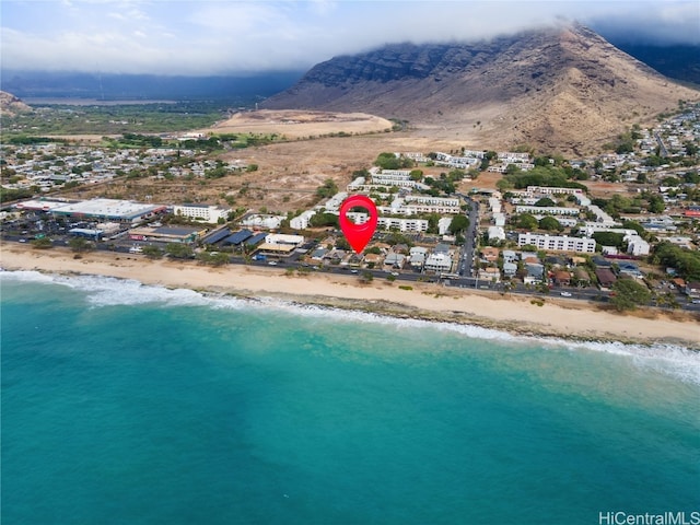 birds eye view of property featuring a view of the beach and a water and mountain view