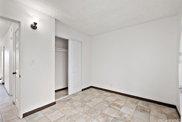 unfurnished bedroom with a textured ceiling and a closet