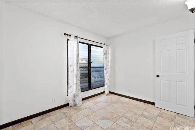 tiled spare room with a textured ceiling