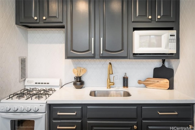 kitchen with sink, white appliances, and tasteful backsplash