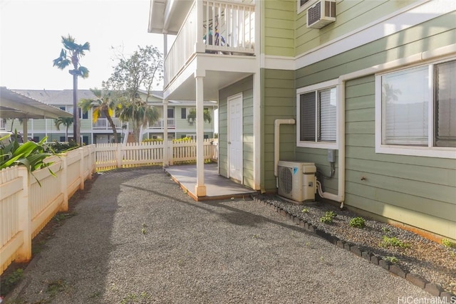 view of patio with a wall mounted air conditioner, ac unit, and a balcony