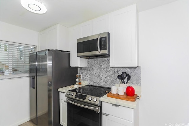 kitchen featuring decorative backsplash, white cabinetry, and stainless steel appliances