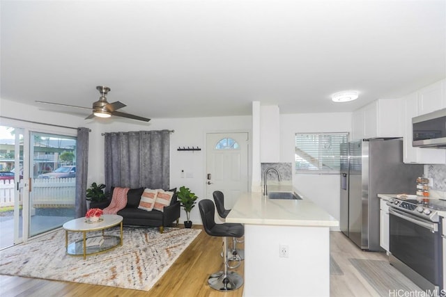 kitchen featuring appliances with stainless steel finishes, tasteful backsplash, white cabinetry, and sink