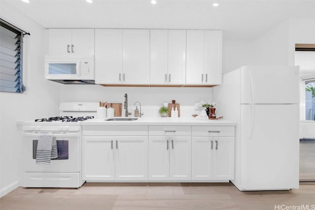 kitchen featuring sink, white appliances, white cabinets, and light wood-type flooring