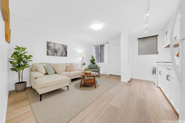 living room with rail lighting and light wood-type flooring