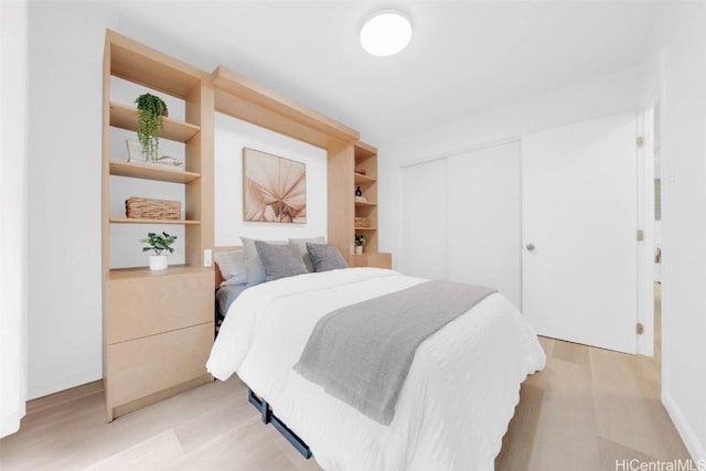 bedroom with a closet and light hardwood / wood-style flooring