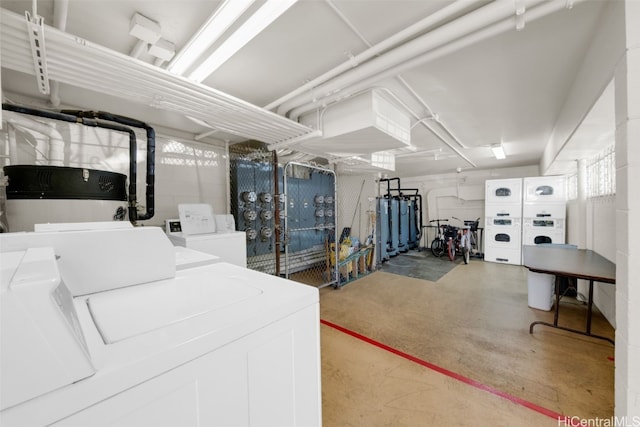 clothes washing area with stacked washer and dryer, washer and dryer, and water heater