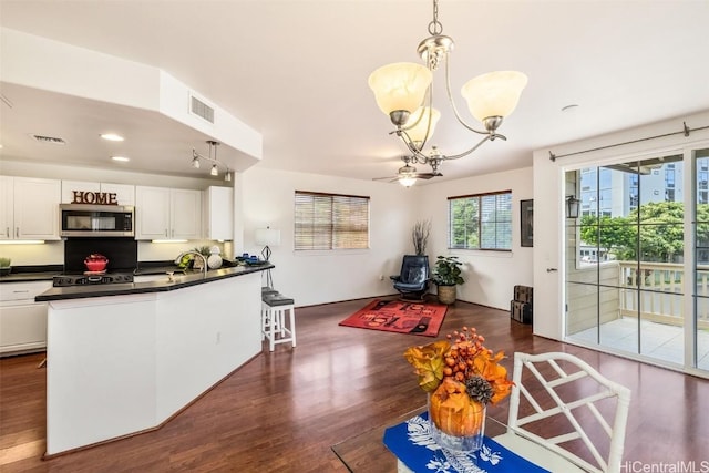 kitchen with white cabinets, pendant lighting, dark hardwood / wood-style floors, and an inviting chandelier