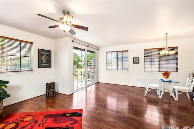 living room featuring dark hardwood / wood-style flooring and ceiling fan with notable chandelier