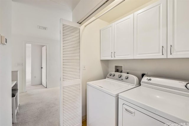 laundry room featuring cabinets, independent washer and dryer, and light colored carpet