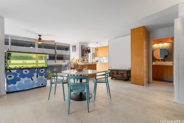 dining area with ceiling fan and sink