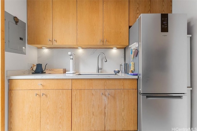 kitchen featuring stainless steel fridge, electric panel, and sink