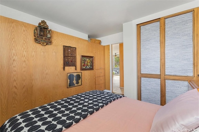 bedroom featuring wooden walls