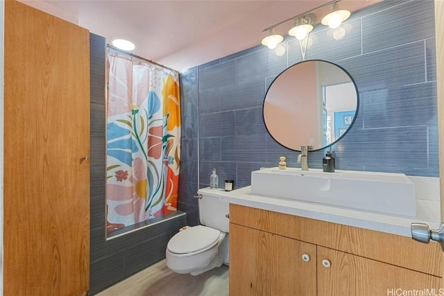 full bathroom with vanity, toilet, tile walls, and shower / tub combo