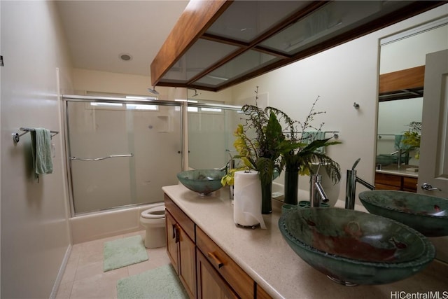 full bathroom featuring tile patterned floors, vanity, toilet, and combined bath / shower with glass door