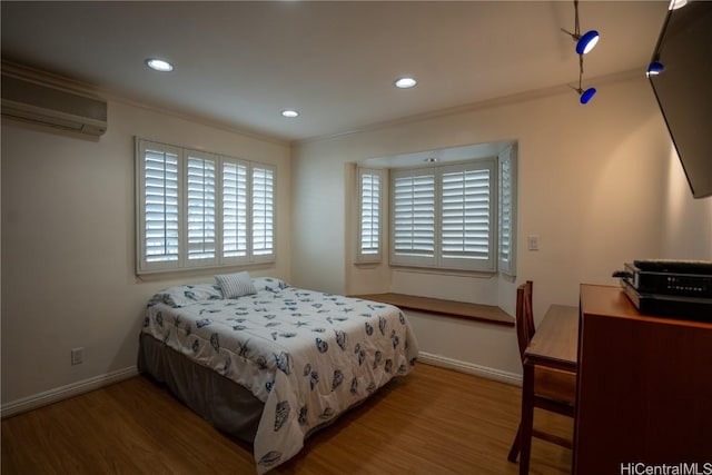 bedroom with crown molding, wood-type flooring, and a wall mounted air conditioner