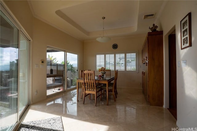 dining area featuring a tray ceiling and crown molding