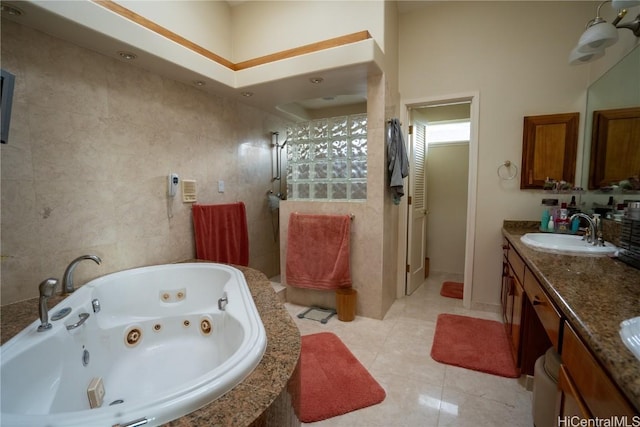 bathroom with separate shower and tub, tile patterned flooring, vanity, and tile walls