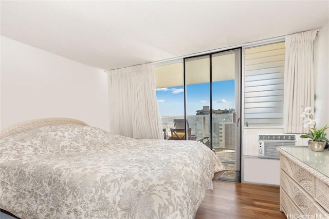 bedroom with cooling unit, access to exterior, and dark wood-type flooring