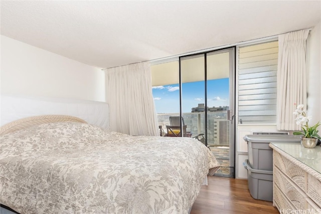 bedroom featuring wood-type flooring and access to outside