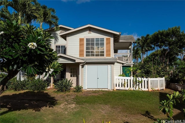 rear view of property with a lawn and a balcony