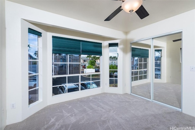 unfurnished sunroom with ceiling fan