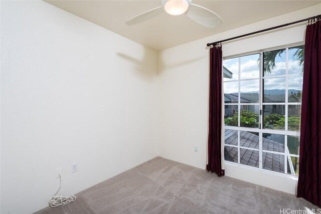 spare room with a mountain view, ceiling fan, and light carpet