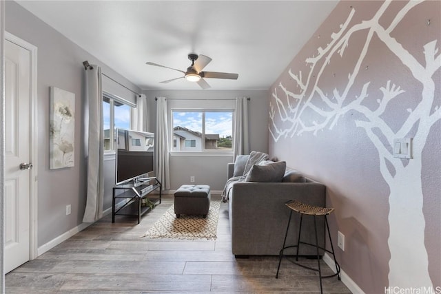 living area featuring hardwood / wood-style floors and ceiling fan