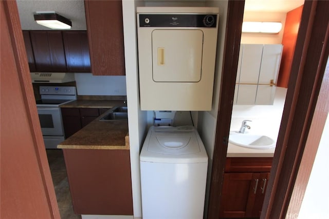 laundry room featuring stacked washer / dryer, sink, and cabinets