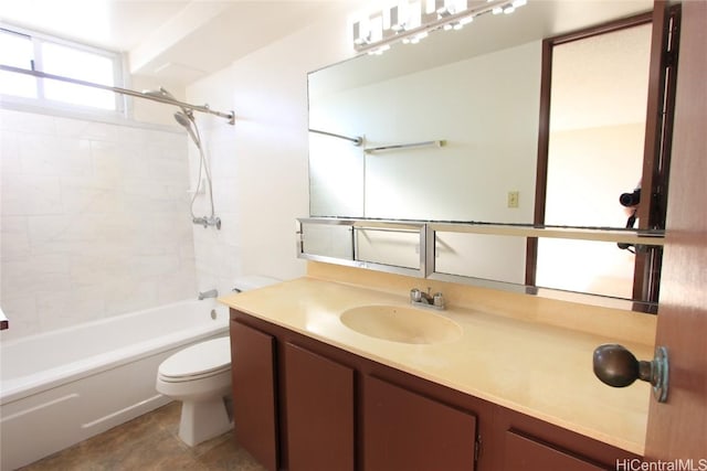 full bathroom featuring vanity, tiled shower / bath, and toilet