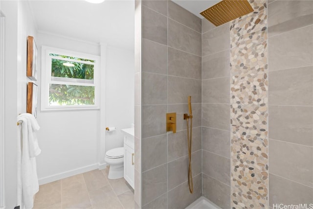 bathroom featuring vanity, a tile shower, and toilet