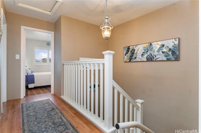 corridor featuring wood finished floors and an upstairs landing