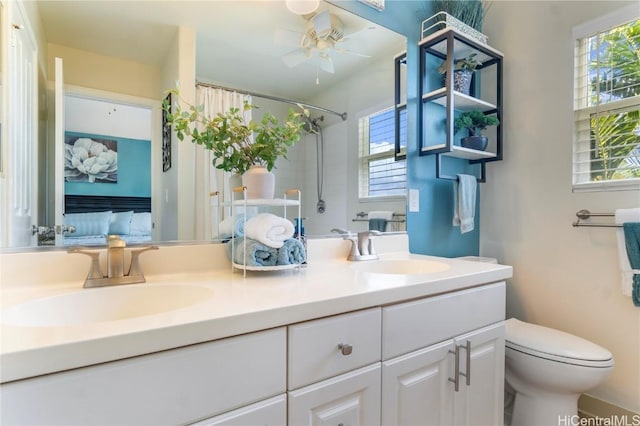 bathroom featuring double vanity, a sink, toilet, and a shower with curtain