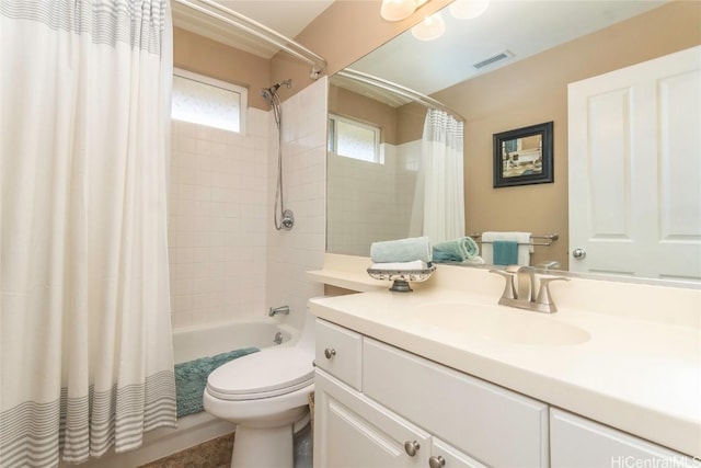 bathroom featuring visible vents, vanity, toilet, and shower / bath combo with shower curtain