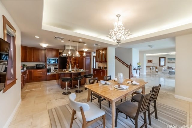 tiled dining room featuring a raised ceiling, sink, and a notable chandelier