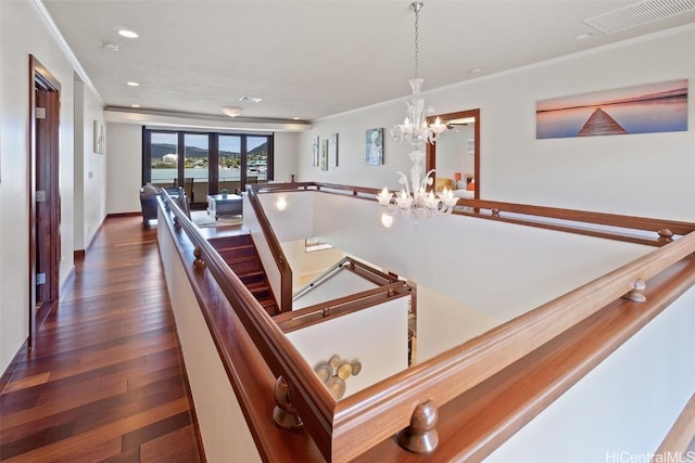 interior space featuring dark wood-type flooring, crown molding, and a notable chandelier