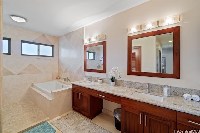 bathroom featuring tile patterned floors, vanity, and tiled tub