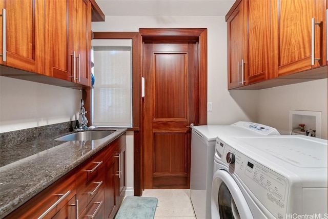 laundry room featuring cabinets, light tile patterned flooring, washing machine and clothes dryer, and sink