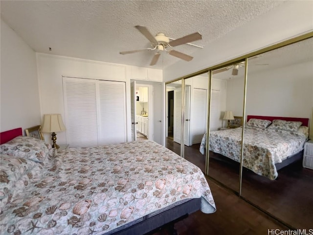 bedroom with dark wood-style flooring, ceiling fan, and a textured ceiling