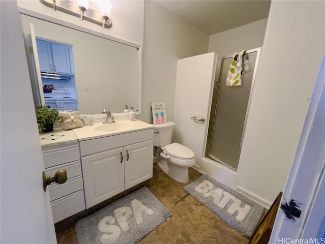 bathroom featuring toilet, a stall shower, and vanity