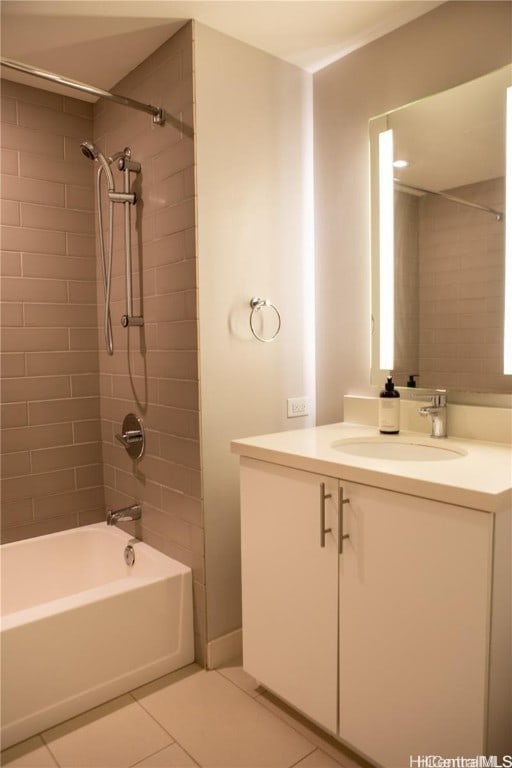 bathroom with tile patterned floors, vanity, and tiled shower / bath