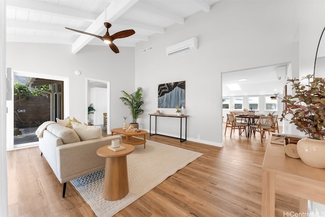 living room with lofted ceiling with beams, hardwood / wood-style flooring, a wall mounted AC, and ceiling fan