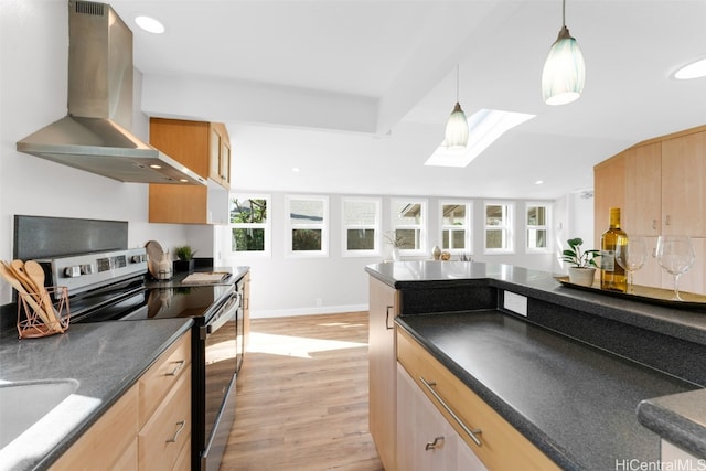 kitchen featuring stainless steel range with electric cooktop, wall chimney range hood, hanging light fixtures, a skylight, and light wood-type flooring