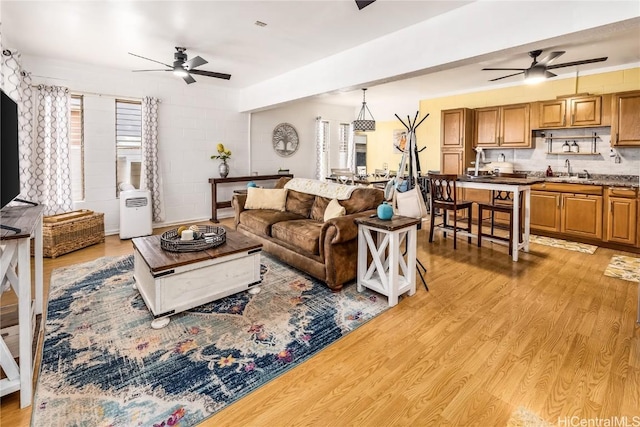 living room featuring a wealth of natural light, ceiling fan, and light hardwood / wood-style floors