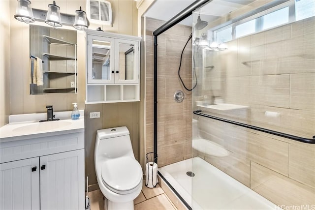 bathroom featuring tile patterned floors, vanity, toilet, and a shower with door