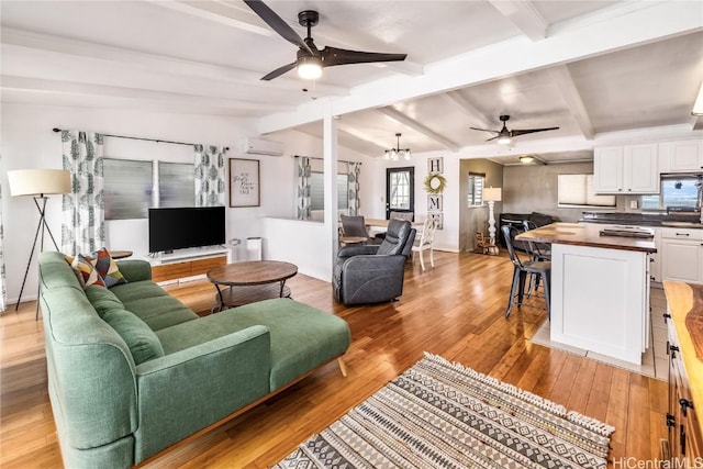 living room with vaulted ceiling with beams, ceiling fan with notable chandelier, light hardwood / wood-style flooring, and a wall mounted AC