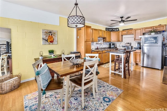 dining area with ceiling fan, sink, and light hardwood / wood-style flooring