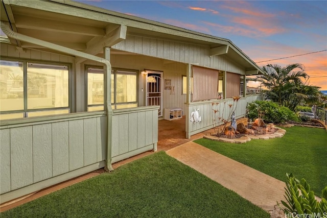 property exterior at dusk with a lawn